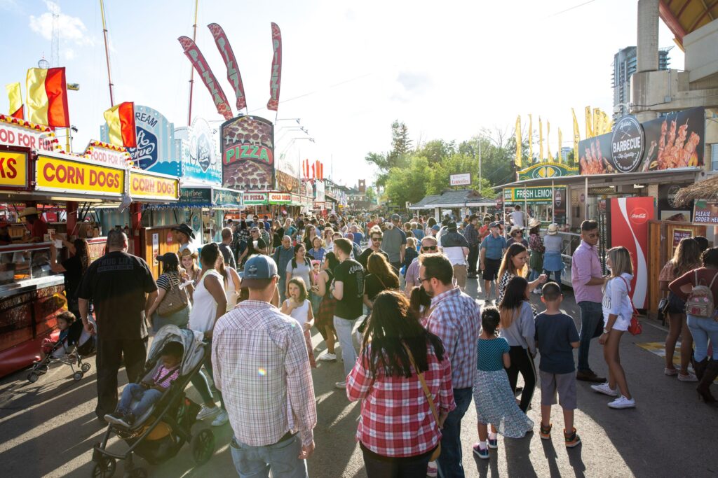 Image of people at the Calgary stampede surrounded by food stands.