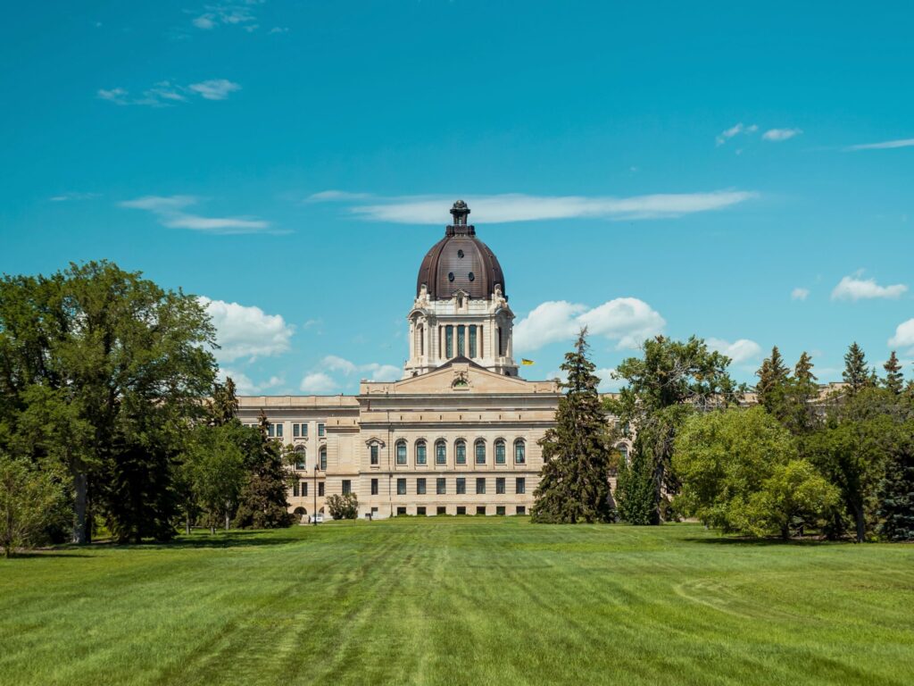 Image of the Saskatchewan Legislative Building with a large green field in front of it.