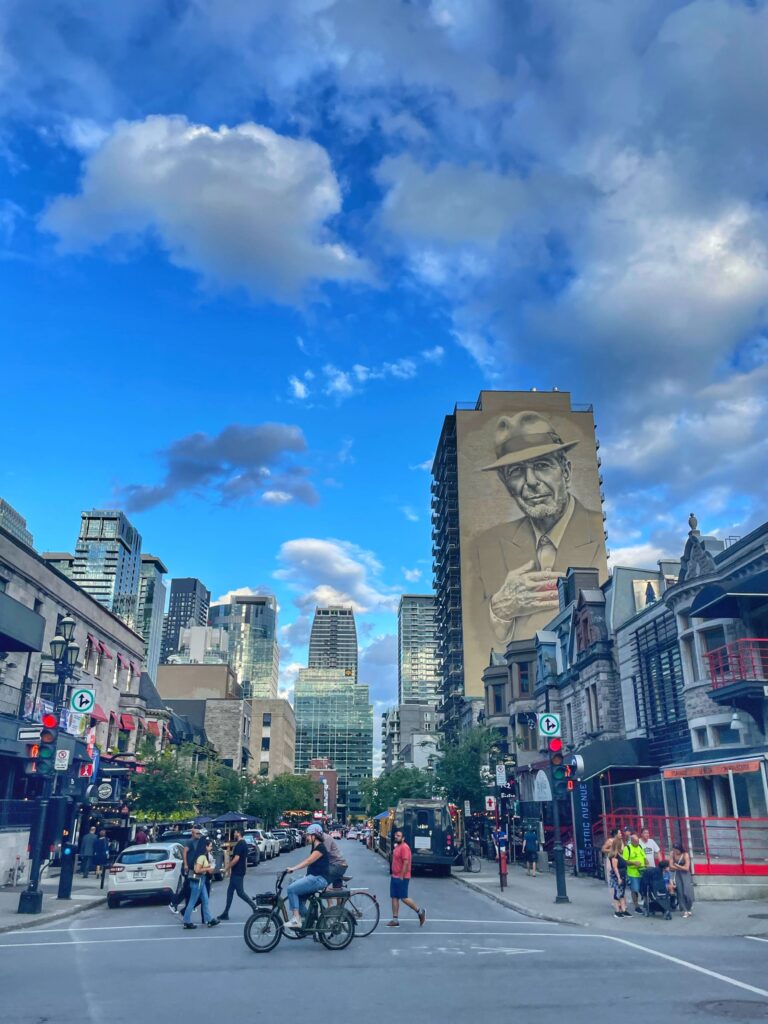 Photo of people cycling on the road in front of the Montreal skyline.