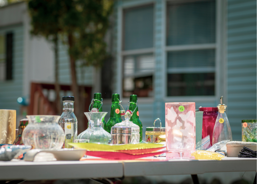 Glassware for sale on table at a garage sale.