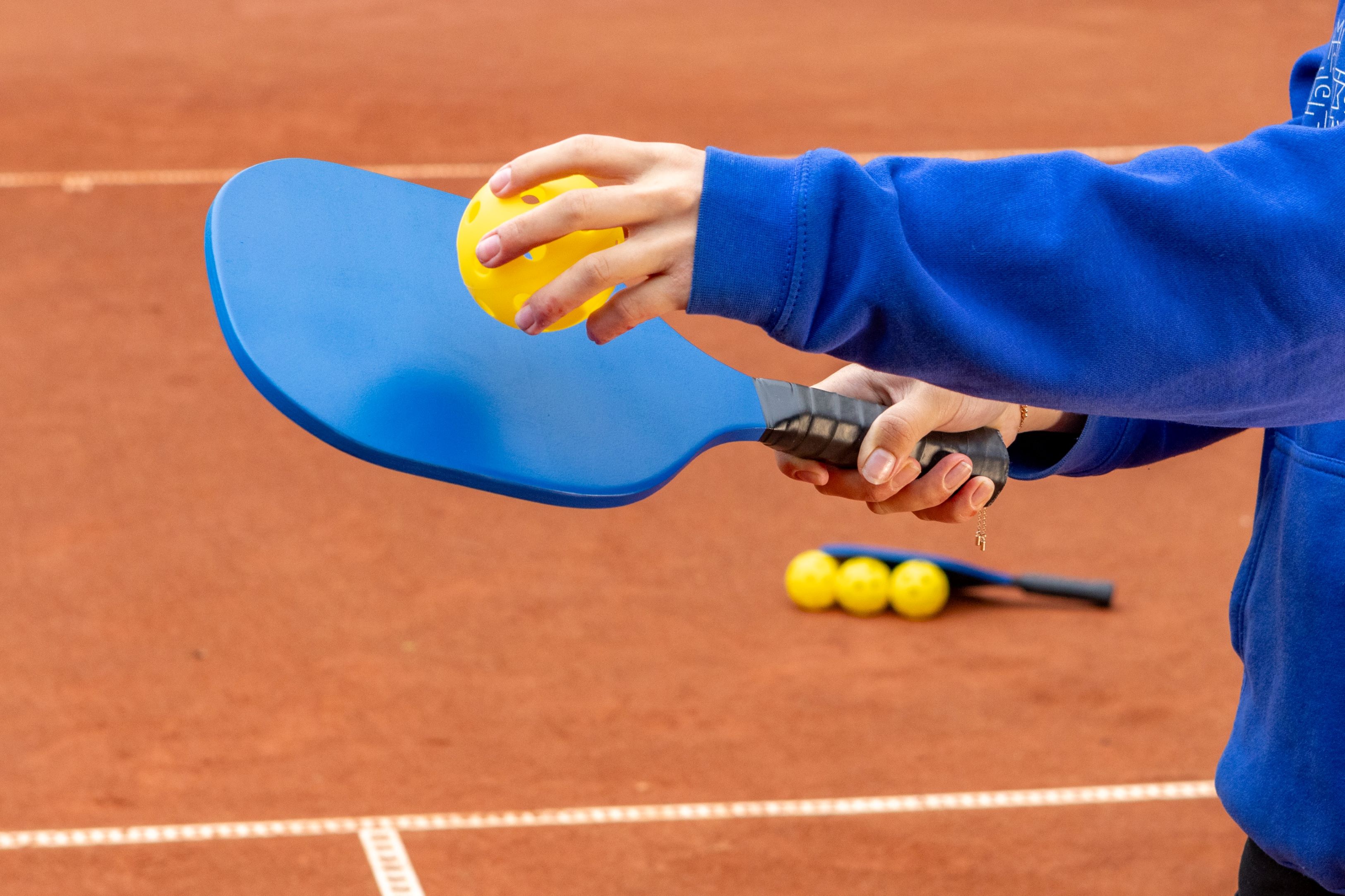 Someone preparing to serve in a pickleball game.