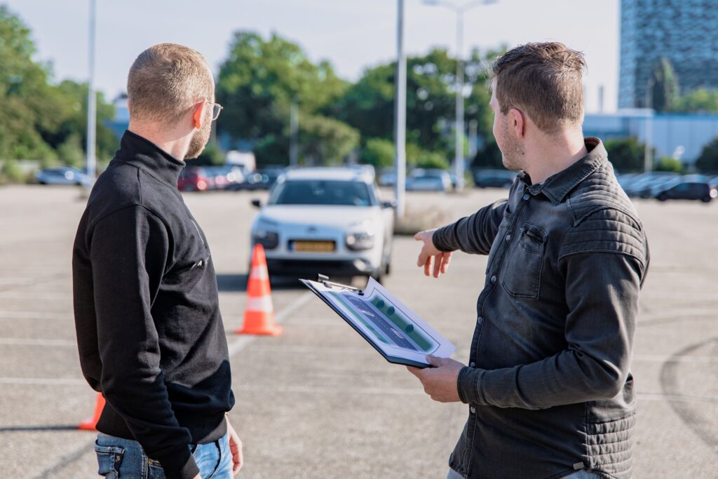 People preparing for a BC driver's license road test in a parking lot.